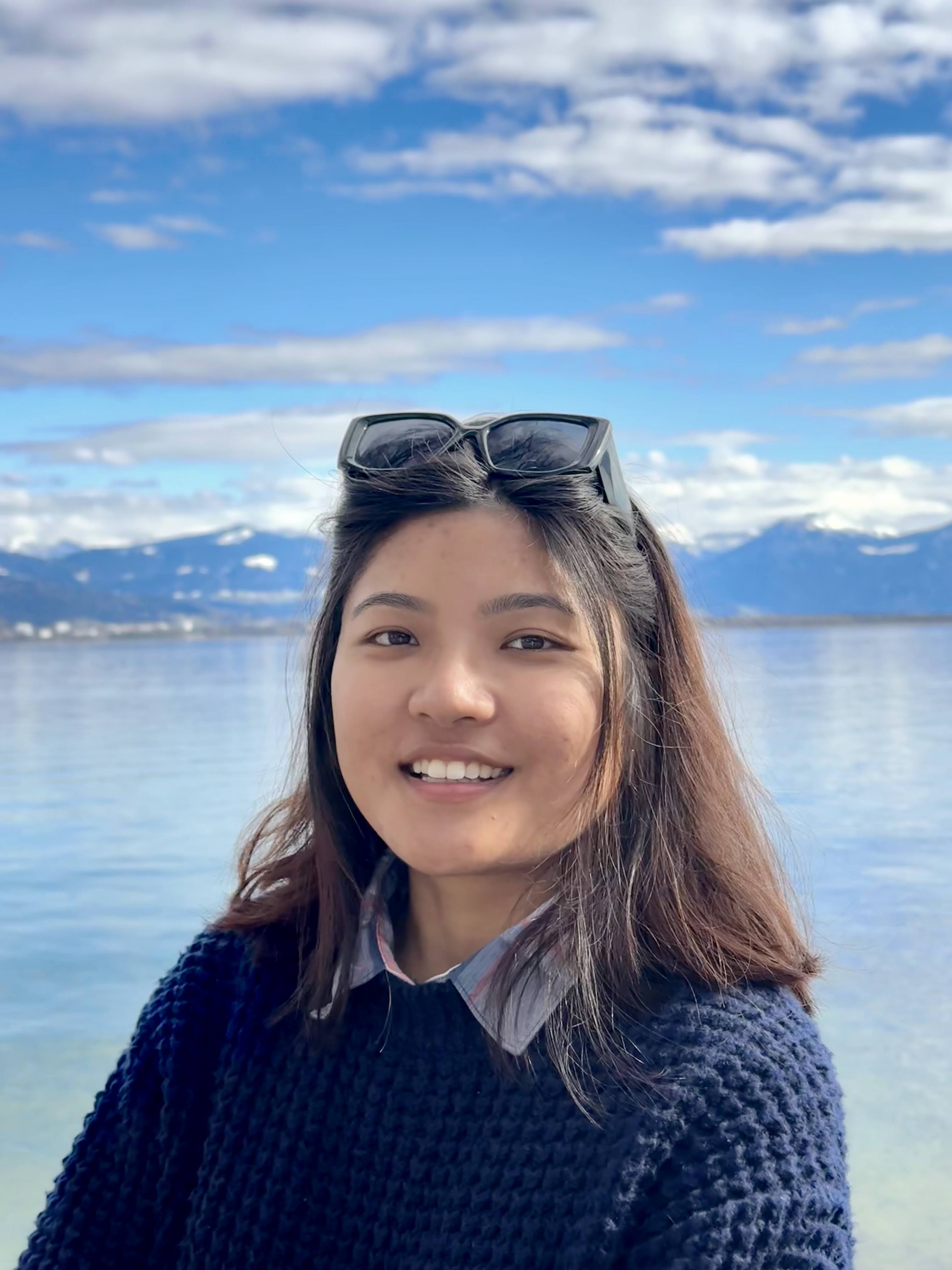 Prahelika Deka beside a lake with mountains in the background
